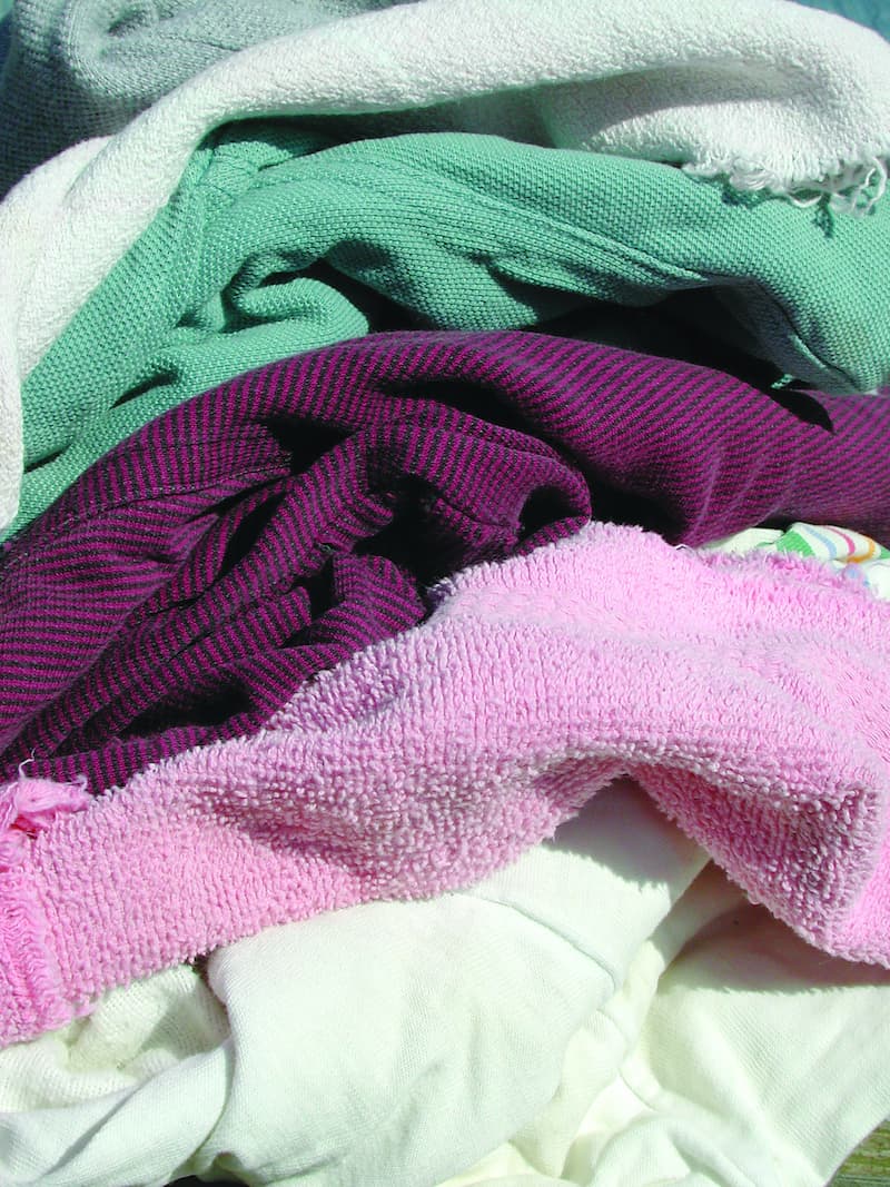 A neatly arranged pile of folded clothes in various colors, showcasing a tidy and organized appearance