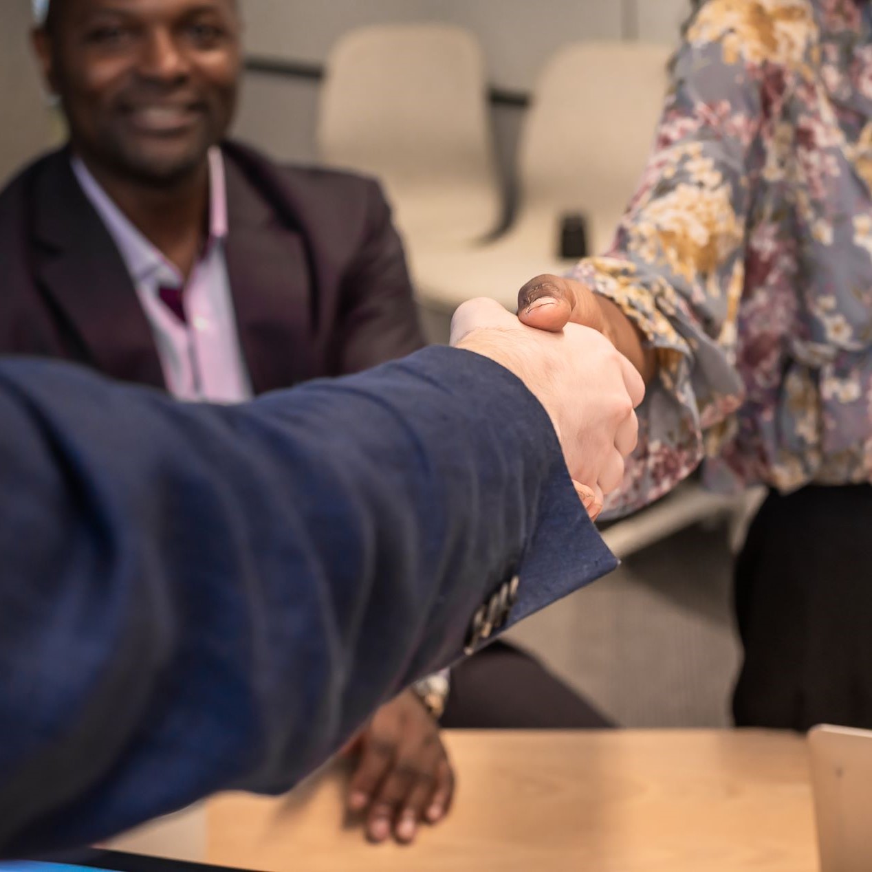 business people shaking hands in an office setting