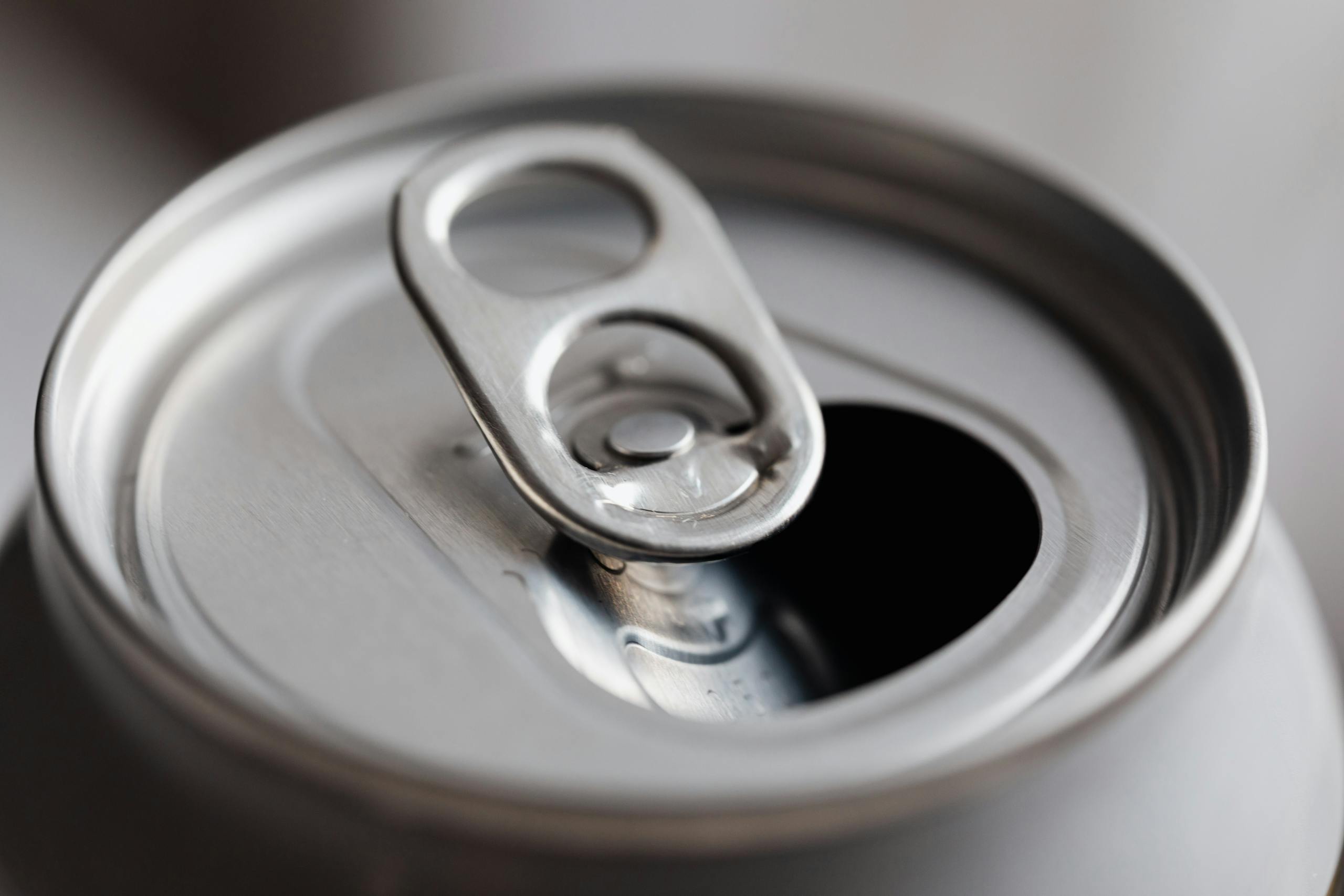 Close-up view of an open aluminum can, highlighting its metallic texture and design.