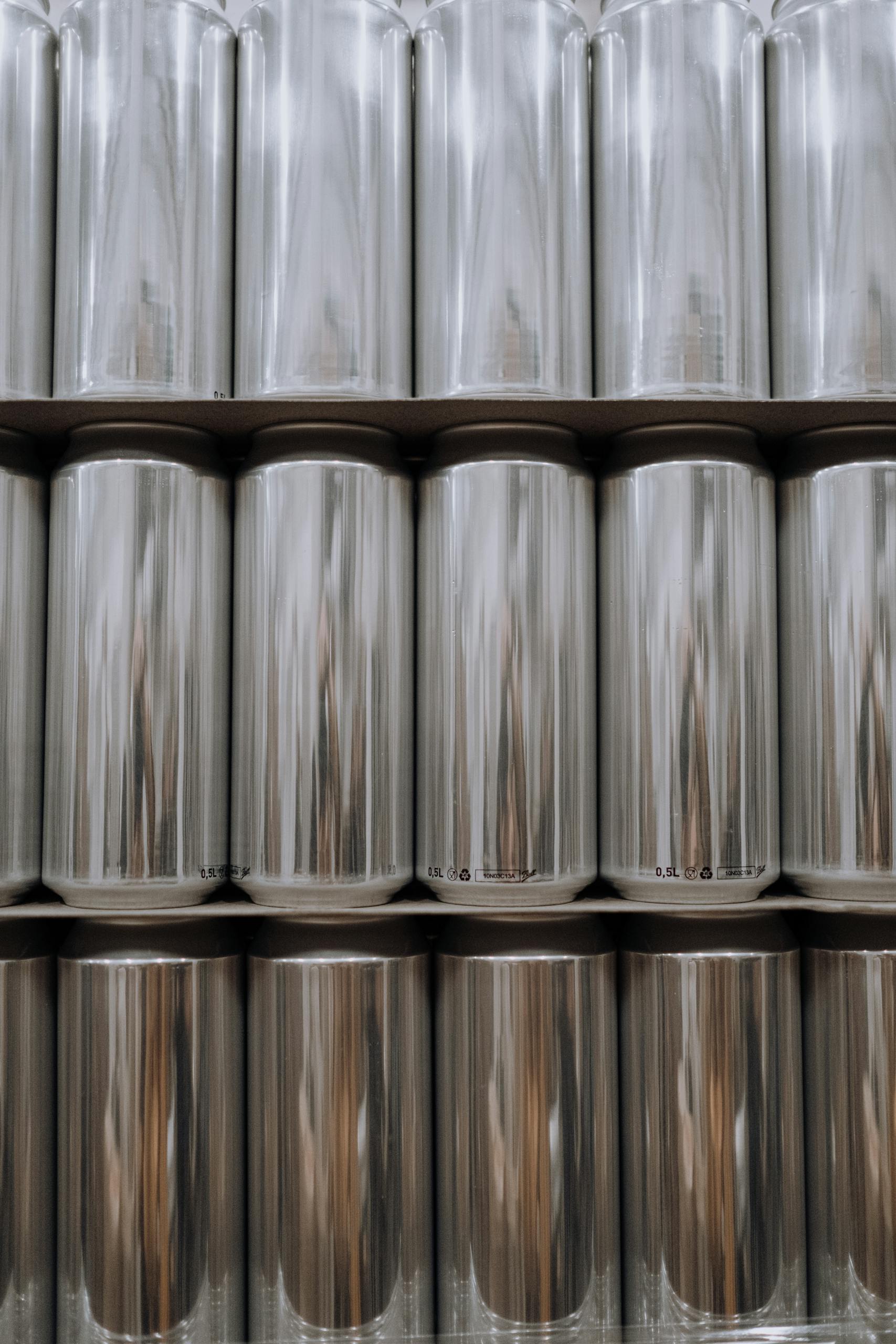 Vertical shot of stacked aluminum cans in an industrial warehouse.